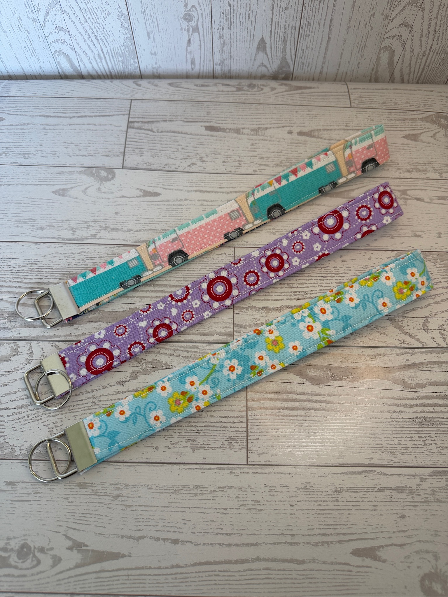 Three handmade key fob wristlets in retro camper, lavender medallion and aqua daisy prints
