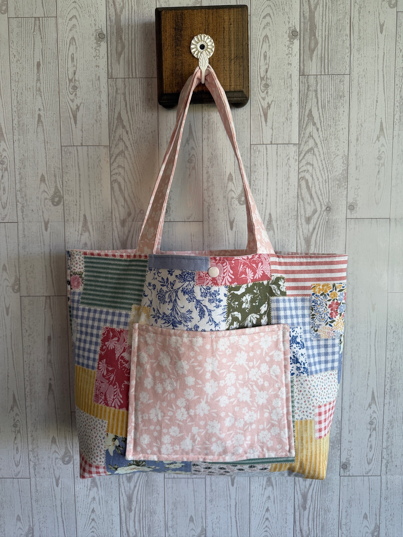 Handmade patchwork tote bag pieced from floral and striped fabrics with a blush floral front pocket