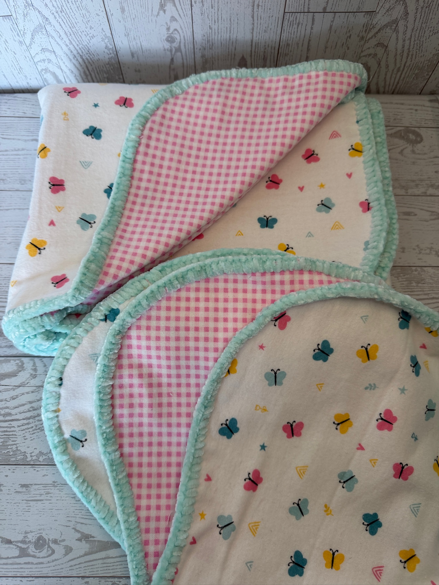 Handmade butterfly flannel baby blanket with pink gingham reverse and mint chenille trim