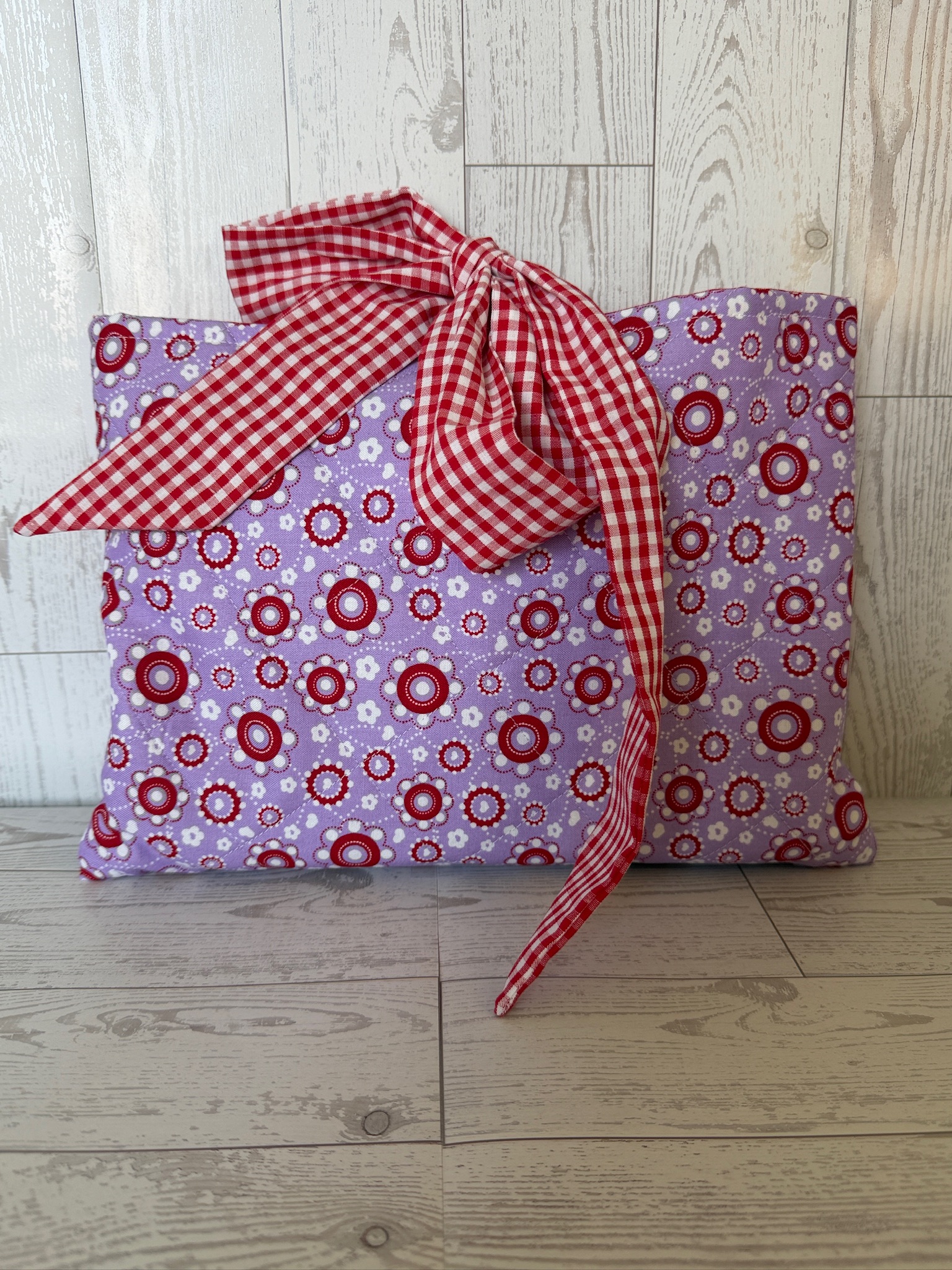 Two handmade lavender medallion book sleeves in matching sizes with a red gingham bow closure