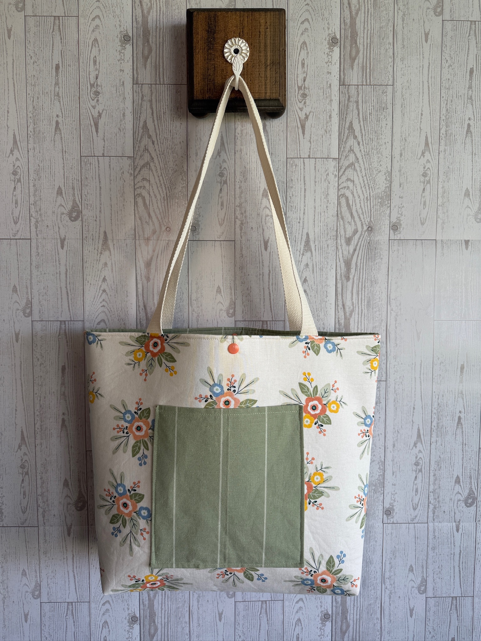 Handmade cream wildflower tote bag with a sage green front pocket