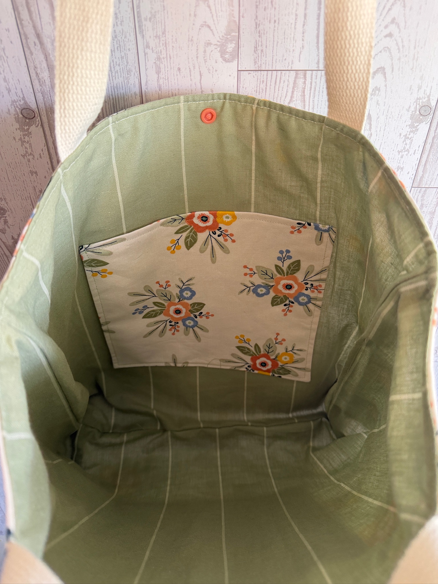 Interior of the wildflower tote bag showing sage green lining and a floral slip pocket