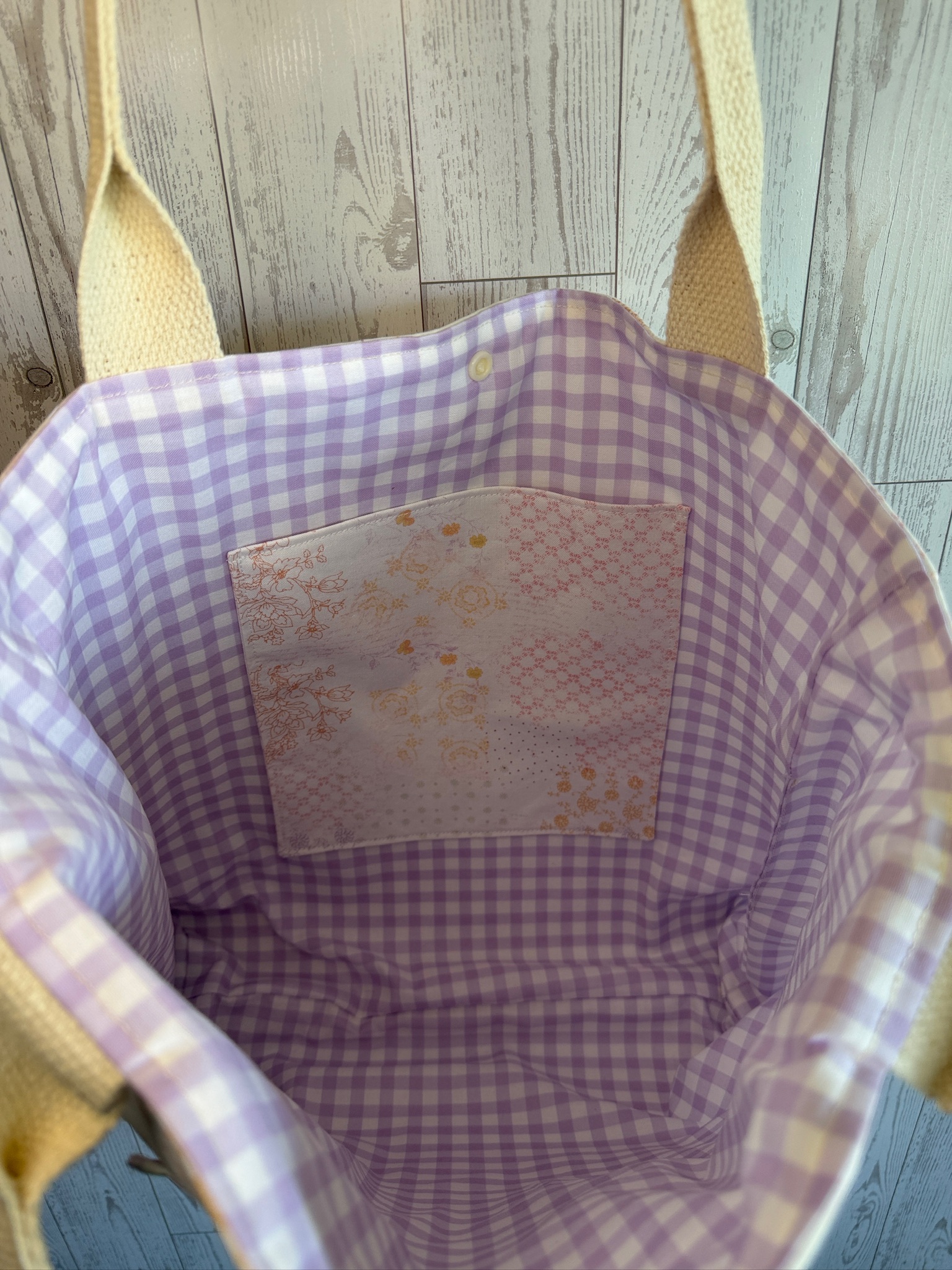 Interior of the tote bag showing lavender gingham lining and a floral slip pocket
