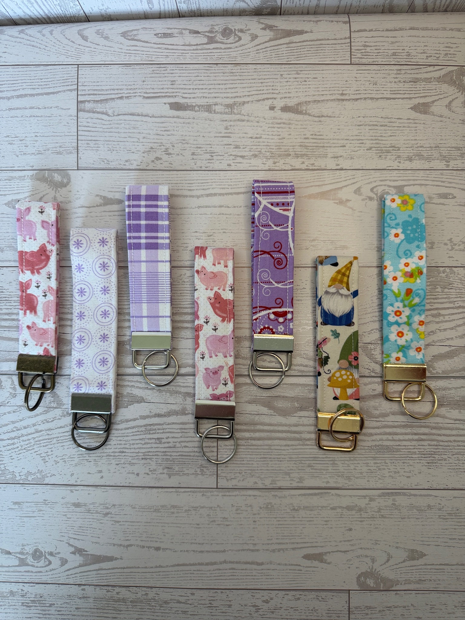 Set of handmade fabric key fob wristlets fanned out in novelty and floral prints