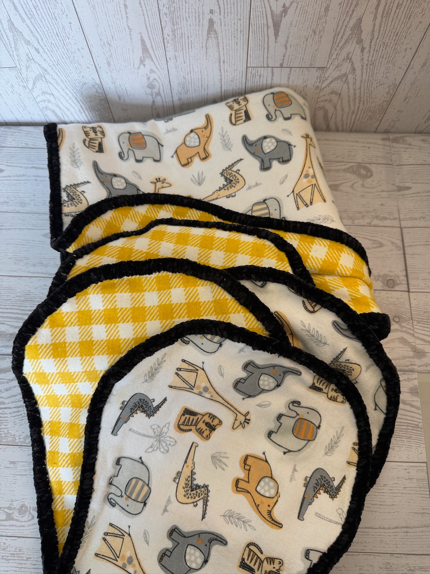 Handmade safari animal flannel baby blanket with yellow plaid reverse and black chenille trim