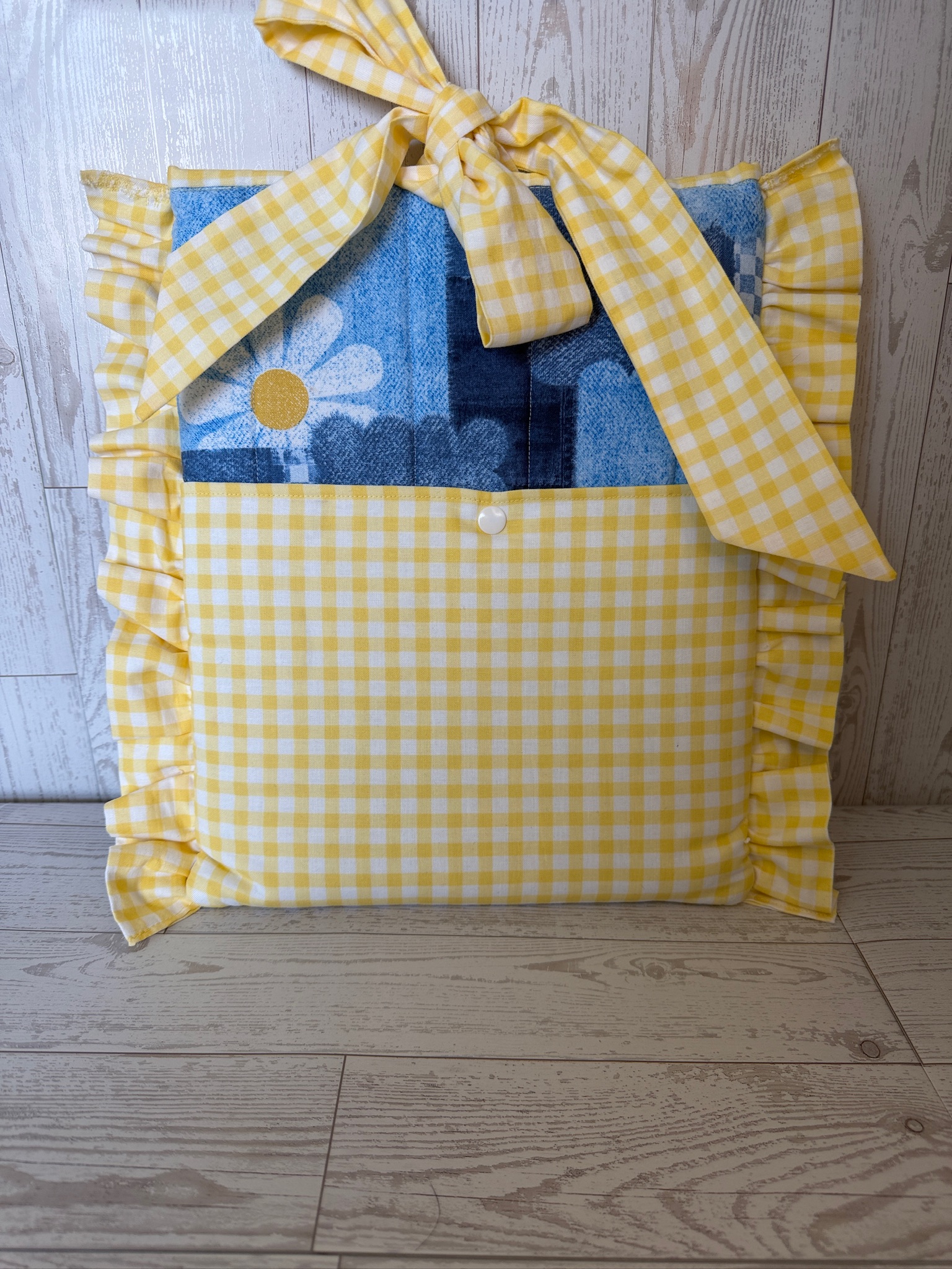 Handmade yellow gingham ruffled book sleeve with a patchwork denim daisy pocket and gingham bow