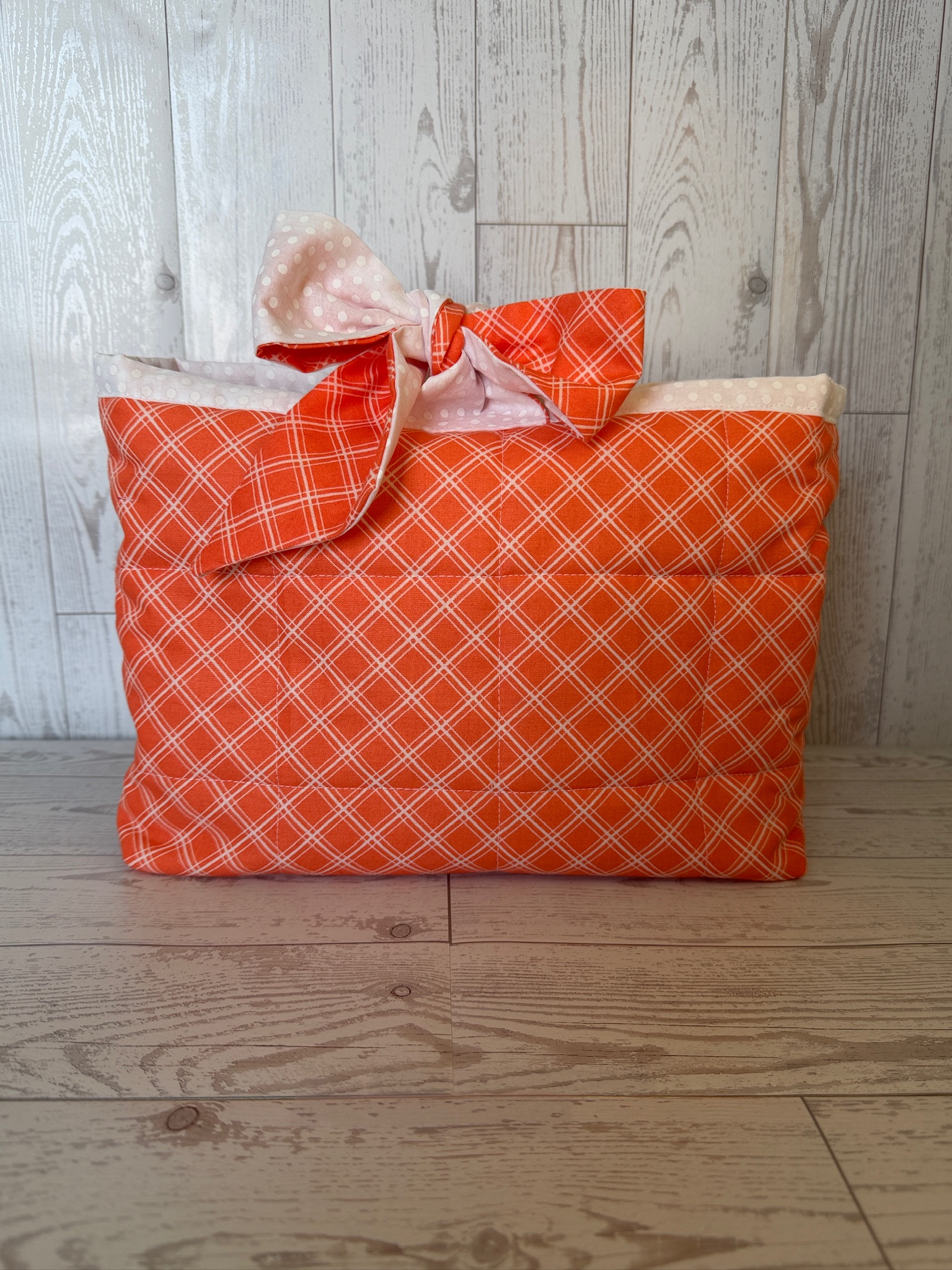 Handmade orange plaid padded book sleeve with an orange gingham fabric tie closure
